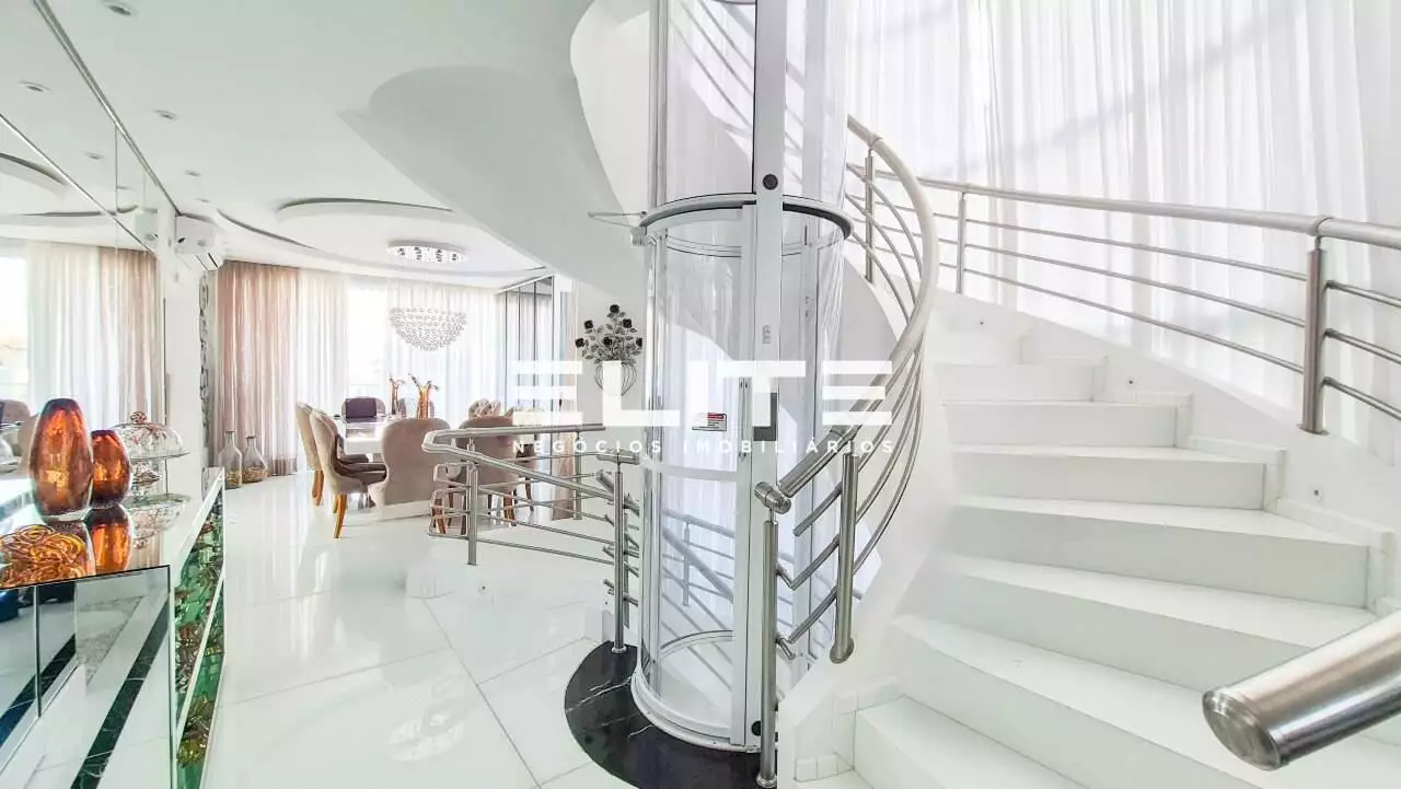 Hall com escada em curva e elevador panorâmico